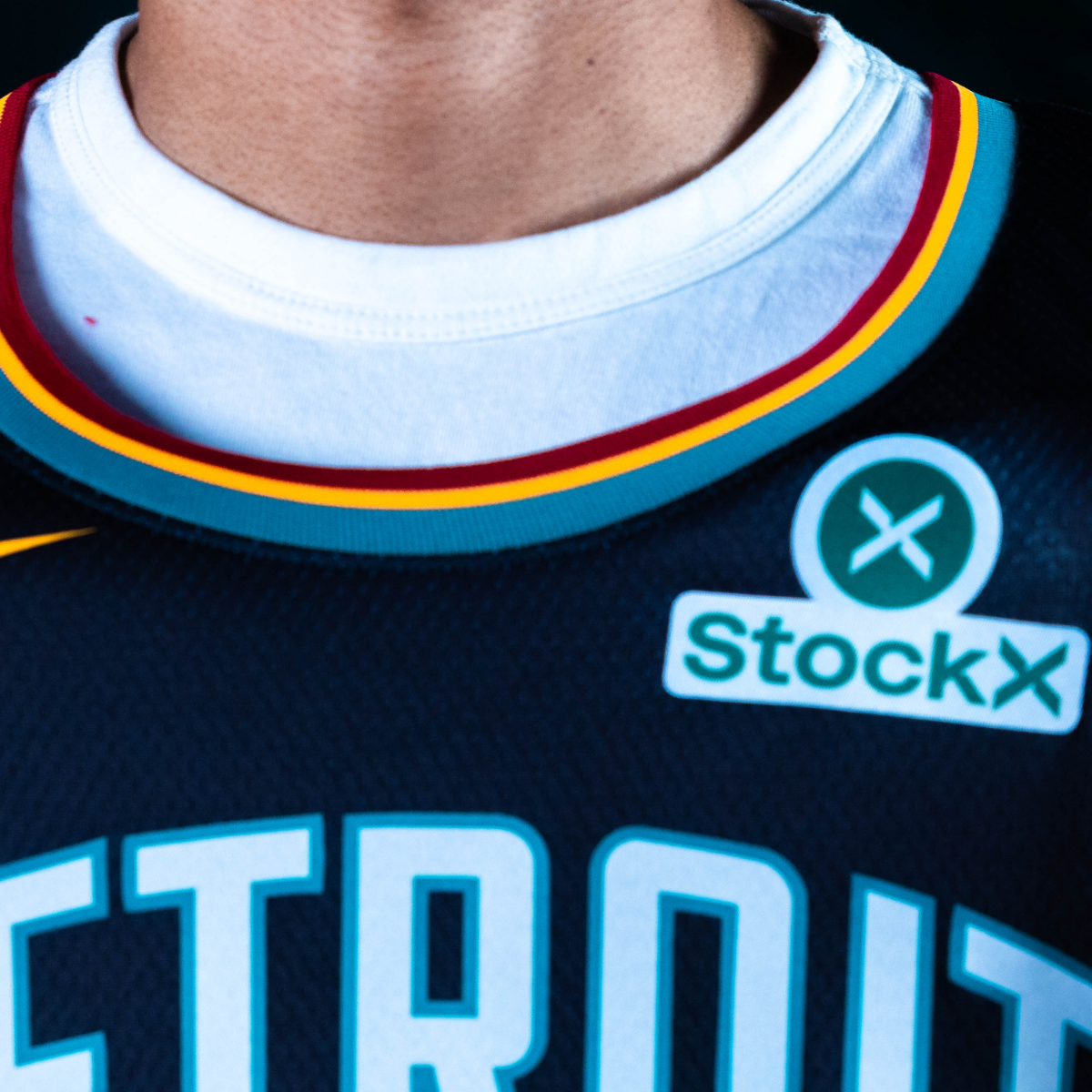 Tri-colored uniform trim stacks '90's era maroon, sundial yellow, and teal around the collar, arm, and leg openings.